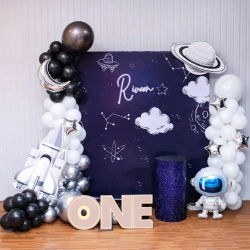 Space theme first birthday balloon decoration with astronaut backdrop and balloon arch in Mumbai